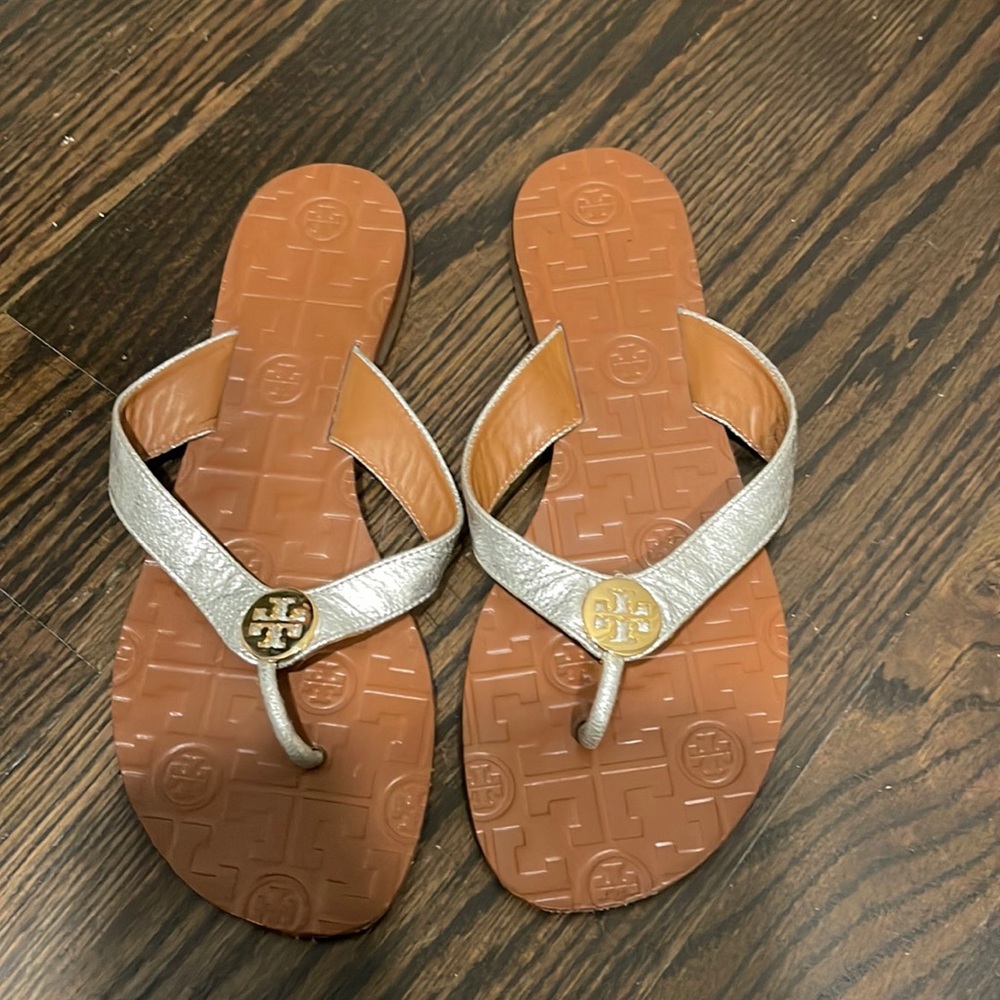 Tory Burch leather flip flops with silver straps and gold emblem size 7